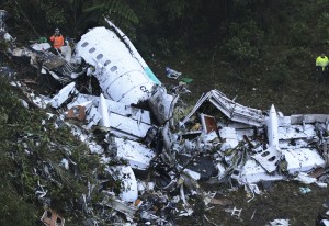 Rescue workers stand at the wreckage site of a chartered airplane that crashed in a mountainous area outside Medellin, Colombia, Tuesday, Nov. 29, 2016. The plane was carrying the Brazilian first division soccer club Chapecoense team that was on it's way for a Copa Sudamericana final match against Colombia's Atletico Nacional. (AP Photo/Luis Benavides)